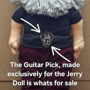 May include: A plush doll with a gray beard, glasses, and a black shirt. A guitar pick pendant with a hand symbol hangs from the doll's neck. The text on the image says, "The Guitar Pick, made exclusively for the Jerry Doll is whats for sale."