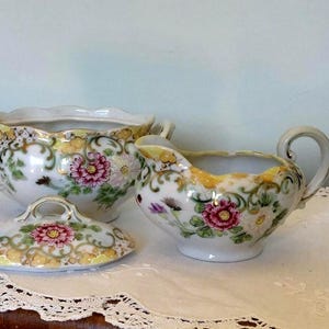 Beautiful vintage sugar bowl and creamer, sugar bowl 9 x 13cm wide. Daisies and gold trimming on this unusual set.  Shabby chic, ornamental