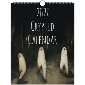 May include: A 2027 wall calendar with a black background and white text that reads 2027 Cryptid Calendar. The cover features an illustration of three pale, upright, humanoid figures with single dark eye-like spots in a dark, wooded forest setting.