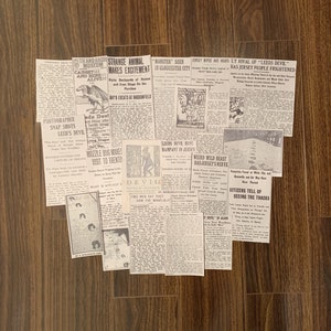 May include: A collection of vintage newspaper clippings with headlines about strange animals, monsters, and the "Leeds Devil". The clippings are arranged on a wooden surface.