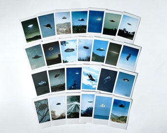 May include: A collection of 24 Polaroid-style photographs, each featuring a different image of a UFO, arranged in a semi-circle pattern on a white background.