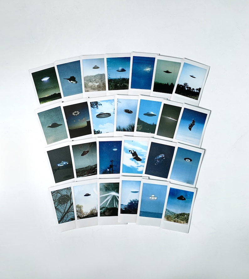 Puede incluir: Una colecci&oacute;n de 24 fotos de estilo Polaroid, cada una con una imagen diferente de un OVNI, dispuestas en forma de semic&iacute;rculo sobre un fondo blanco.