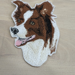 Peut inclure: Patch brodé représentant un border collie brun et blanc avec la langue rose qui sort. Le chien regarde vers la gauche.