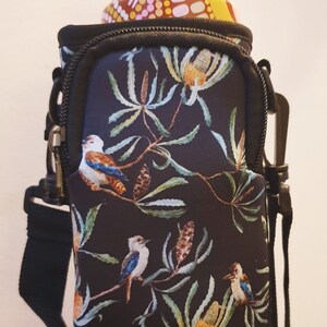 K&ouml;nnte beinhalten: Schwarzer Neopren-Wasserflaschenhalter mit Blumen- und Vogelmotiv. Der Halter hat einen Rei&szlig;verschluss und einen verstellbaren Riemen. Die Flasche ist nicht im Lieferumfang enthalten.