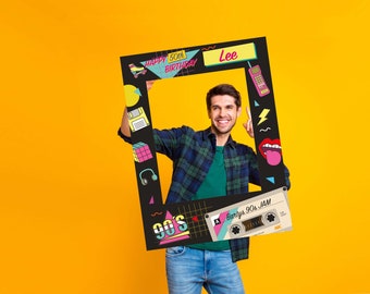 May include: A black and white photo booth prop with a 90s theme. It features a cassette tape, a boombox, a Rubik's cube, a floppy disk, headphones, a roller skate, a phone, and a lightning bolt. The text on the prop says "Happy 50th Birthday" and "Party's 90s Jam".