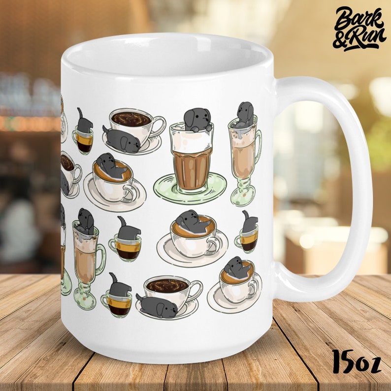 May include: White ceramic coffee mug with a black and white illustration of dogs in coffee cups. The mug has a black handle and the text "Bark & Run" is printed on the top right corner. The mug is 15 oz.