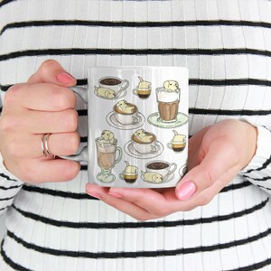 May include: White ceramic mug with a design of multiple small dogs in various coffee cups and glasses. The dogs are all light brown and have black eyes and noses.