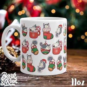 May include: White ceramic mug with a Christmas-themed design featuring a pattern of cartoon huskies in various holiday settings, including a stocking, a mug of hot chocolate, and a Christmas ornament. The mug is 11 oz.