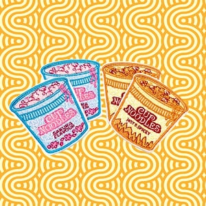 Peut inclure: Quatre patchs brodés thermocollants représentant différents parfums de nouilles instantanées. Les patchs sont colorés et présentent le texte "Cup Noodles" et "Sakura Flavor".