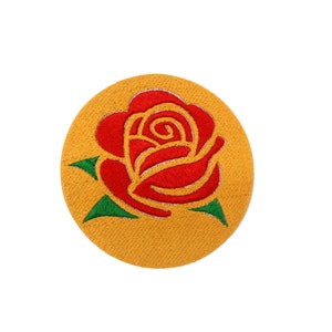 May include: A red embroidered rose with green leaves on a yellow circular patch.