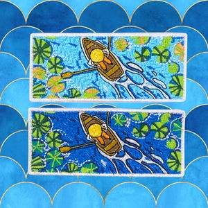 May include: Two embroidered patches depicting a person rowing a boat on a blue lake with green lily pads. The patches are white with a white outline.