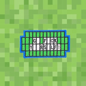 Puede incluir: Parche bordado con el texto "G FCK YRS LF!" en blanco sobre una cuadrícula verde, contorneado en azul. El fondo es un patrón verde pixelado.