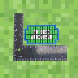 May include: Embroidered patch with the text "G FCK YRS LFI" in white block letters, framed by a blue border and green pixelated design. The patch is approximately 2 inches wide and 1 inch tall.