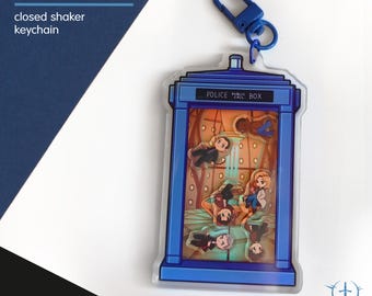 Puede incluir: Un llavero shaker cerrado de Doctor Who con un diseño de cabina de policía azul y el texto POLICE PUBLIC CALL BOX. El dije de acrílico transparente contiene pequeñas figuras flotantes y está unido a un mosquetón de plástico azul.