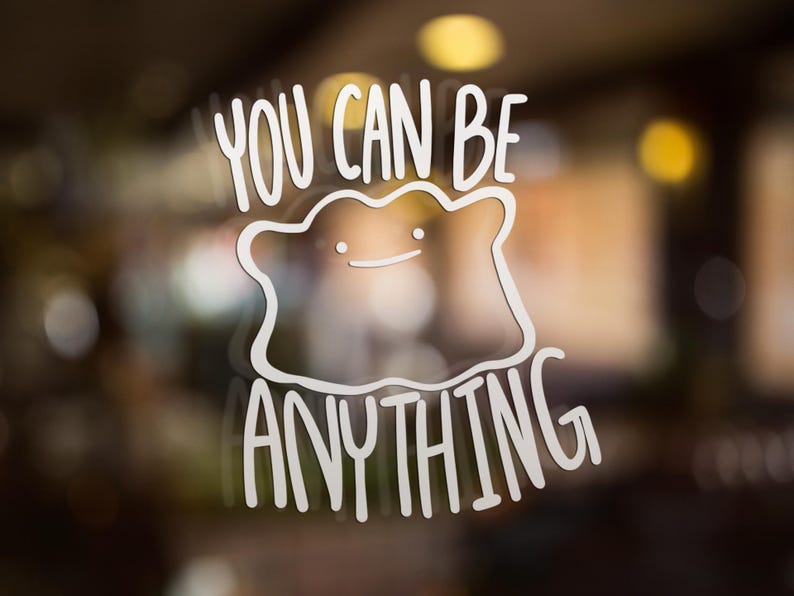 May include: A white vinyl decal featuring a line-art illustration of a blob-shaped creature with two small dots for eyes and a simple curved line for a mouth, accompanied by the text YOU CAN BE ANYTHING in a bold, sans-serif font.