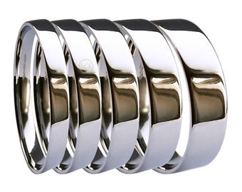 May include: Five silver wedding bands stacked together. The bands are smooth and shiny.