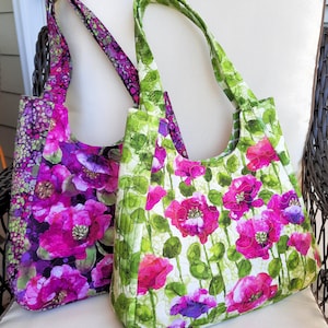 Bolso de hombro tipo hobo acolchado con asa superior, tamaño mediano o grande, con estampado floral de amapolas oscuras o claras, ideal para viajes o compras, listo para regalar.