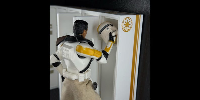 May include: A Star Wars action figure in a white and yellow uniform is placing a helmet into a white locker. The locker has gold stripes and a gold emblem. The figure is wearing a tan skirt.