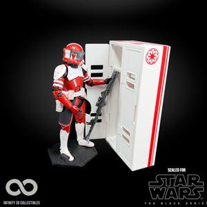May include: A Star Wars action figure of a red and white armored character with a blaster, standing next to a white storage unit with red accents. The figure is on a black base. The words "SCALED FOR STAR WARS THE BLACK SERIES" are visible.