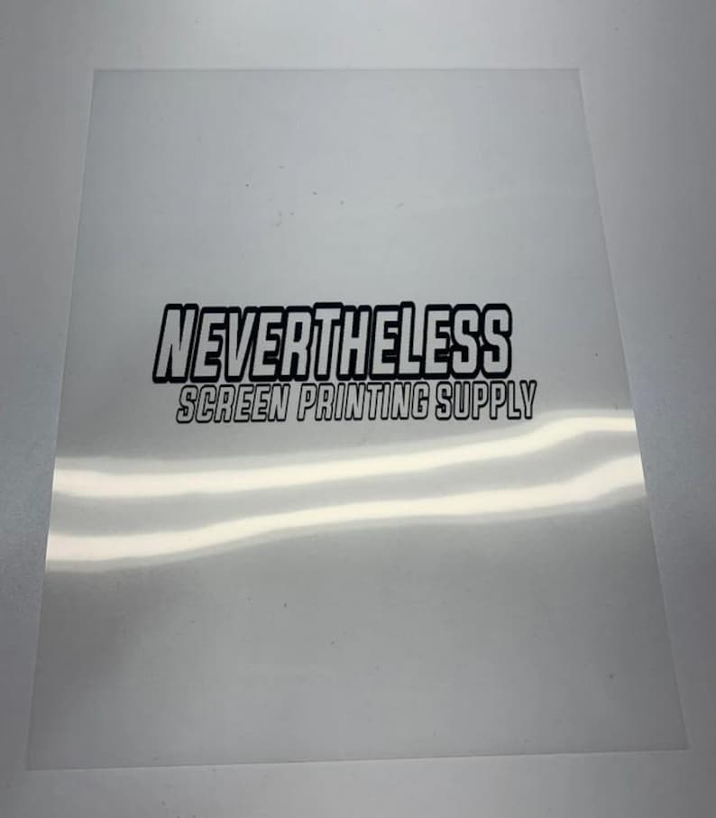 Puede incluir: Una l&aacute;mina transparente para serigraf&iacute;a con el texto "NEVERTHELESS SCREEN PRINTING SUPPLY" en negro y negrita. La l&aacute;mina es rectangular y permite el paso de la luz.