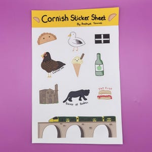 May include: A sticker sheet featuring a selection of Cornish themed illustrations, such as a pasty, a seagull, a Cornish hen, a Cornish ice cream cone, a bottle of cider, the Cornish flag, a Cornish castle, the Beast of Bodmin, a Cornish pasty with jam, and a train on a bridge. The sticker sheet is titled "Cornish Sticker Sheet" and is by Amethyst Teacups.