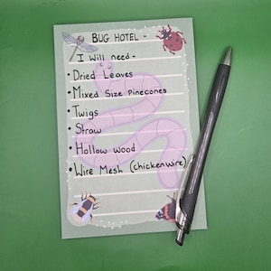 May include: A light green notepad with the text "BUG HOTEL - I Will need - Dried Leaves, Mixed Size Pinecones, Twigs, Straw, Hollow wood, Wire Mesh (chicken wire)". A black pen rests on the notepad. Decorative illustrations of insects are present.