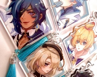 May include: Four colorful anime character keychains with blue tassels. Each keychain features a different character with a unique design and expression. The keychains are made of clear acrylic and have a silver metal ring.