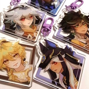 Puede incluir: Cinco llaveros de personajes de anime coloridos con anillos metálicos morados. Cada llavero presenta un personaje diferente con un borde blanco y un fondo morado.