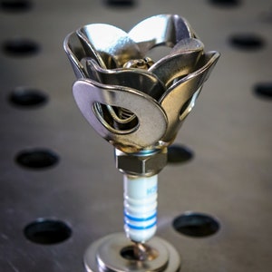 One spark plug rose on steel table