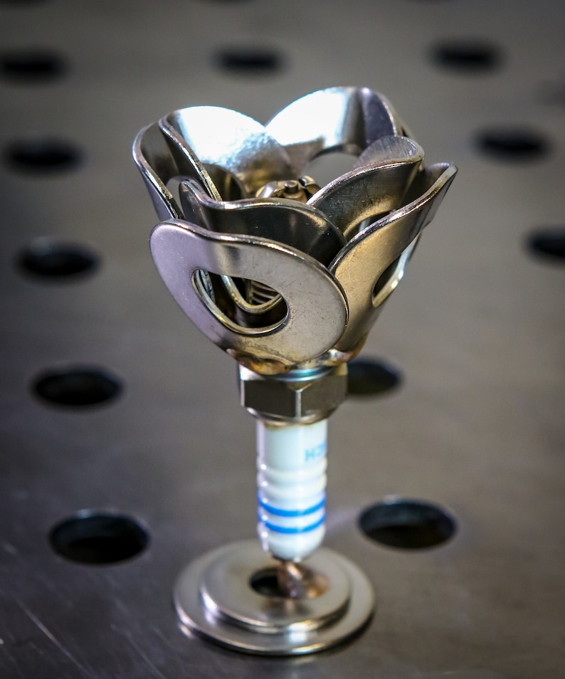 One spark plug rose on steel table