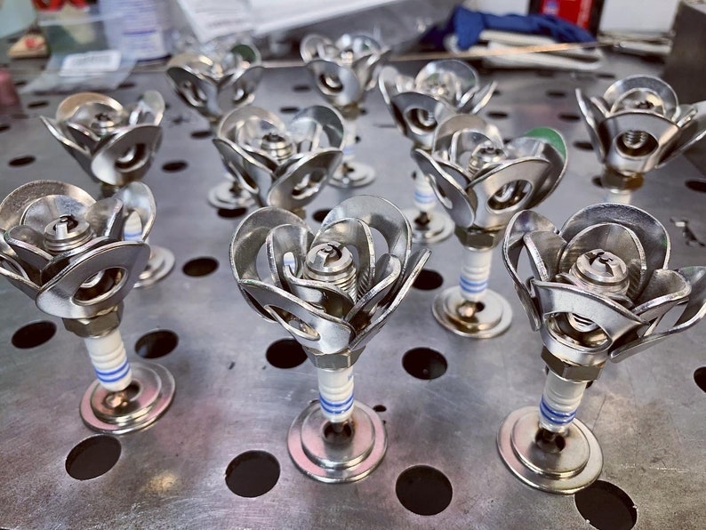 Many spark plug roses on steel table