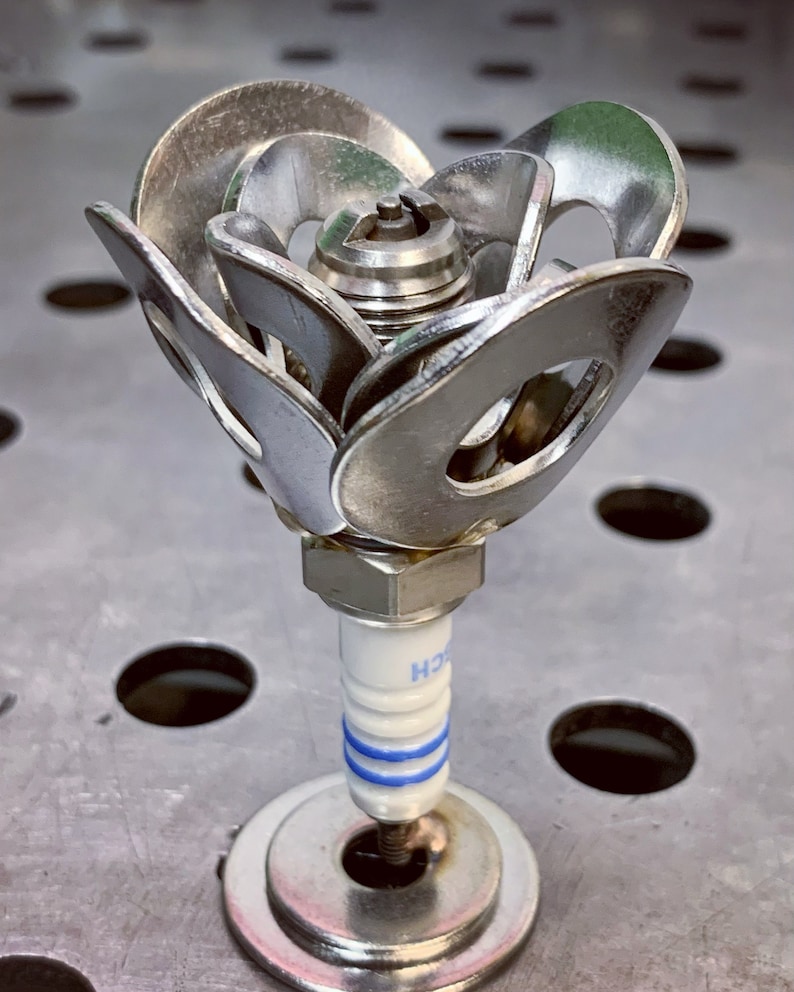 One spark plug rose on steel table