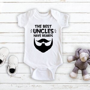 May include: White baby onesie with black text that reads "The Best Uncles Have Beards" and a black and white illustration of a mustache and beard.