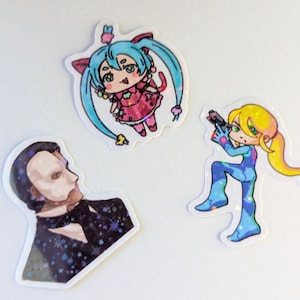 May include: Three colorful stickers featuring cartoon characters. One sticker depicts a character with blue hair and a pink dress. Another shows a figure in a blue and yellow suit holding a gun. The third sticker is a portrait of a man in a tuxedo.