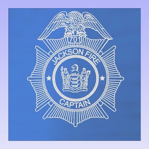 May include: A white badge with a blue background. The badge has a star on each side and a crest in the center. The text on the badge reads "Jackson Fire Captain".