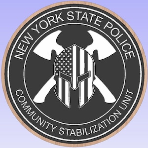 May include: Circular emblem with the text "NEW YORK STATE POLICE COMMUNITY STABILIZATION UNIT." The design includes crossed axes, a helmet with an American flag, and a brown border.
