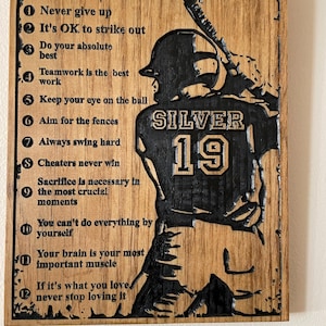 May include: A wooden plaque with a baseball player silhouette and the text "BASEBALL LIFE LESSONS" with a numbered list of 12 life lessons. The player's jersey has the number "19" and the word "SILVER" on it.
