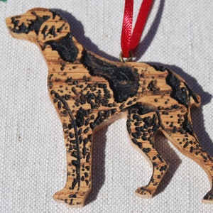 May include: A wooden ornament of a black and brown dog, with a red ribbon attached.