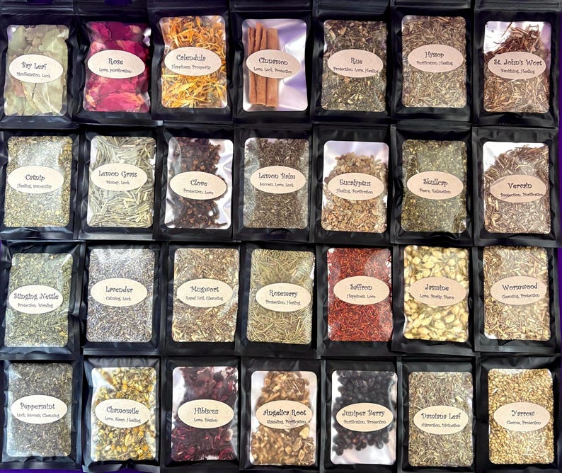 Puede incluir: Una colecci&oacute;n de veintiocho bolsas negras que contienen diversas hierbas y productos bot&aacute;nicos secos. Cada bolsa cuenta con una ventana transparente y una etiqueta beige con el nombre de la hierba y sus propiedades, como laurel, rosa y canela.