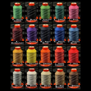 May include: A grid of spools of thread in various colors, including neon green, black, avocado green, green, and pink. Each spool has a red top and is labeled with a letter and color name. The image is on a black background.