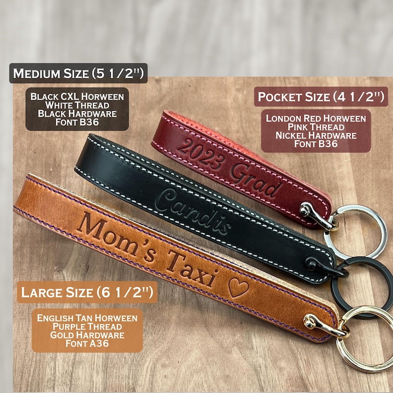 Three handmade leather keychains in large, medium, and pocket sizes.  The large keychain is English tan with purple thread, gold hardware, and the text 'Mom's Taxi' in purple. The medium keychain is black with white thread, black hardware, and the text 'Candis'. The pocket-sized keychain is London red with pink thread, nickel hardware, and the text 'Graduation'. All keychains are handmade to order and feature personalized engravings, high-quality Horween leather and solid brass premium hardware.