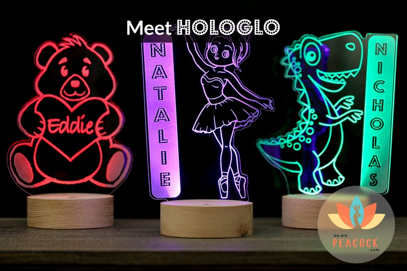 May include: Three personalized LED night lights with different designs. The first is a teddy bear holding a heart with the name "Eddie" on it. The second is a ballerina with the name "Natalie" on it. The third is a dinosaur with the name "Nicholas" on it.