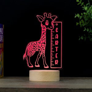 May include: A pink giraffe night light with a wooden base and a height chart that says "CARTER".