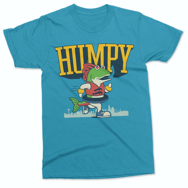 May include: A turquoise t-shirt featuring a cartoon fish character wearing a life vest and running. The word "HUMPY" is printed in yellow above the fish. The fish is green with a red hat and a black inner tube.