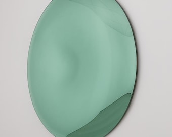Könnte beinhalten: Ein großer, ovaler, mintgrüner Spiegel mit schwarzem Rahmen. Der Spiegel hat eine glatte, reflektierende Oberfläche und ist an einer weißen Wand montiert. Das Design ist minimalistisch und modern, geeignet für die Inneneinrichtung.