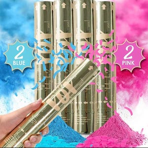 May include: Gold gender reveal poppers with blue and pink powder. The poppers have text that reads "What will baby be?" and "See!" Blue and pink confetti and powder are visible. The image also shows the text "2 Blue" and "2 Pink".