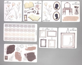 May include: A set of printable planner stickers featuring various illustrations, including flowers, books, keys, a globe, a vanity table with a mirror, a jar of makeup brushes, frames, and lace trim. The stickers are designed in a soft, muted color palette with brown, beige, and white tones. The text "jojo's PRETTY PAPER SHOP" appears on several of the stickers.