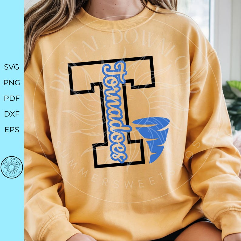 May include: Mustard yellow sweatshirt with a black and blue graphic. The graphic features a large black letter "T" with the word "Tornadoes" in blue script and a blue tornado illustration. The sweatshirt has long sleeves.