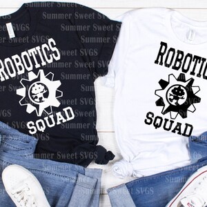 May include: Black and white t-shirts with the text "ROBOTICS SQUAD" and a gear graphic with a robot inside. The shirts are displayed on top of blue jeans and white sneakers.