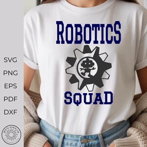 May include: White t-shirt with the words "ROBOTICS SQUAD" in navy blue, along with a gear-shaped graphic containing a robot. The shirt also has the words "SVG, PNG, EPS, PDF, DXF" on the left side.